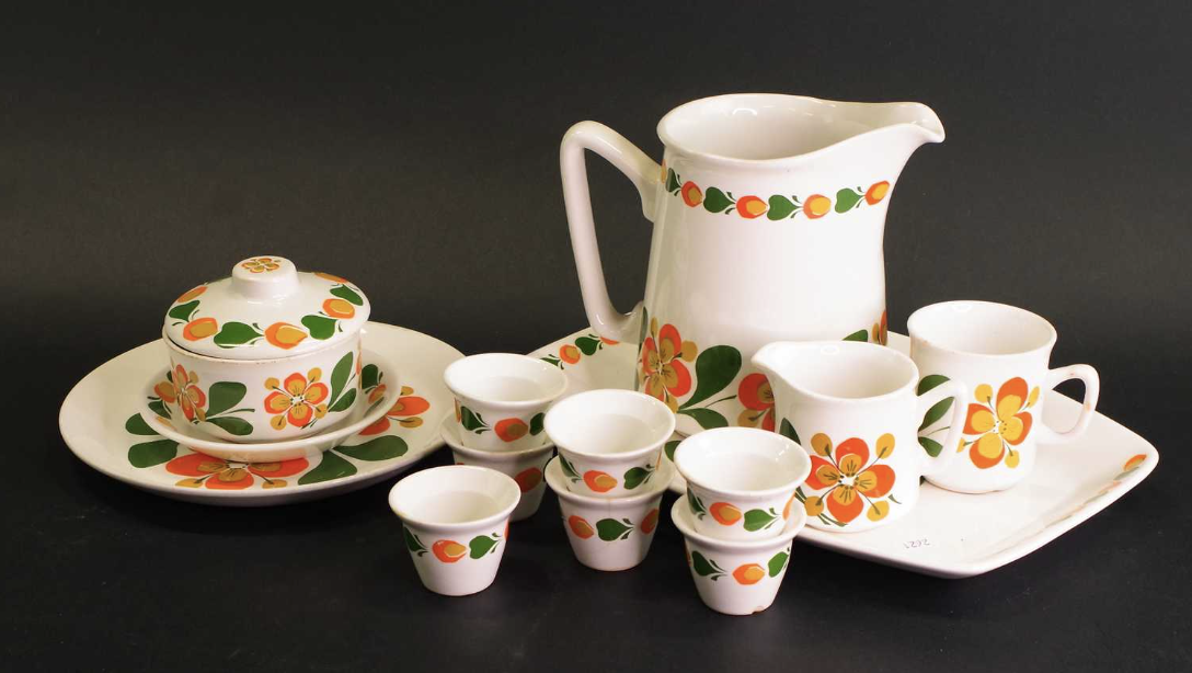 Vintage porslinsservis med kanna, koppar och fat dekorerade med färgglada blommor