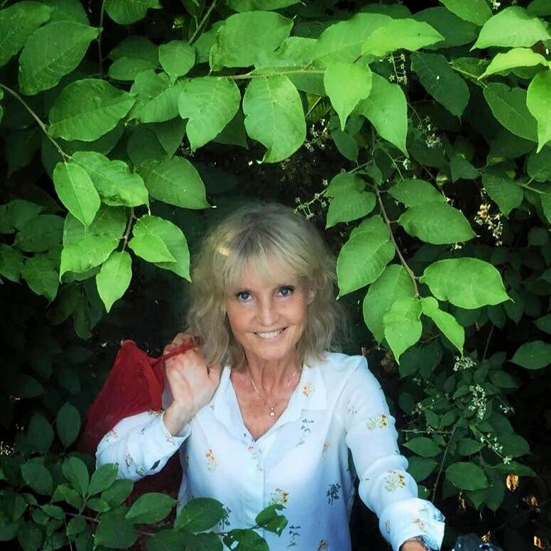 Marie-Louise Eklöf tittar fram under ett träd.