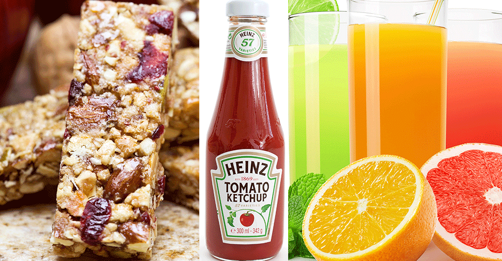 Müslibars, ketchupflaska och glas med färgglada juicer bredvid citrusfrukter