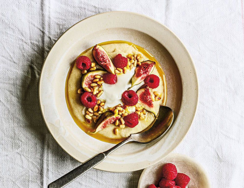 Tallrik med yoghurt, fikon, hallon och nötter.
