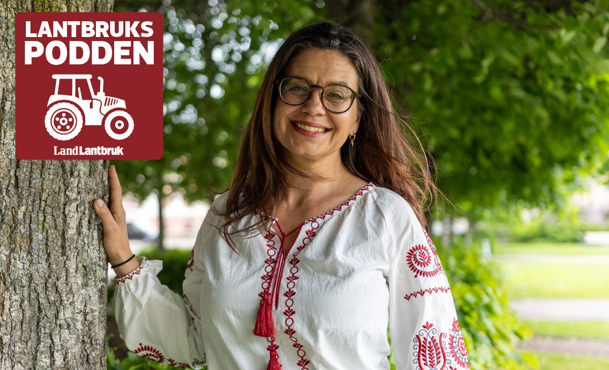 Leende kvinna i broderad blus vid träd, med logotypen Lantbrukspodden i hörnet