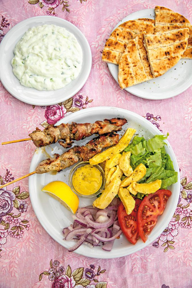 Souvlakispett på tallrik med pitabröd och tzatziki.