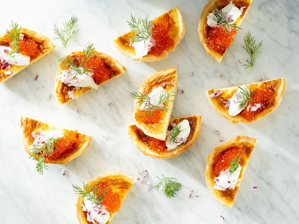 Små snittar med röra och dill på ett marmorbord.