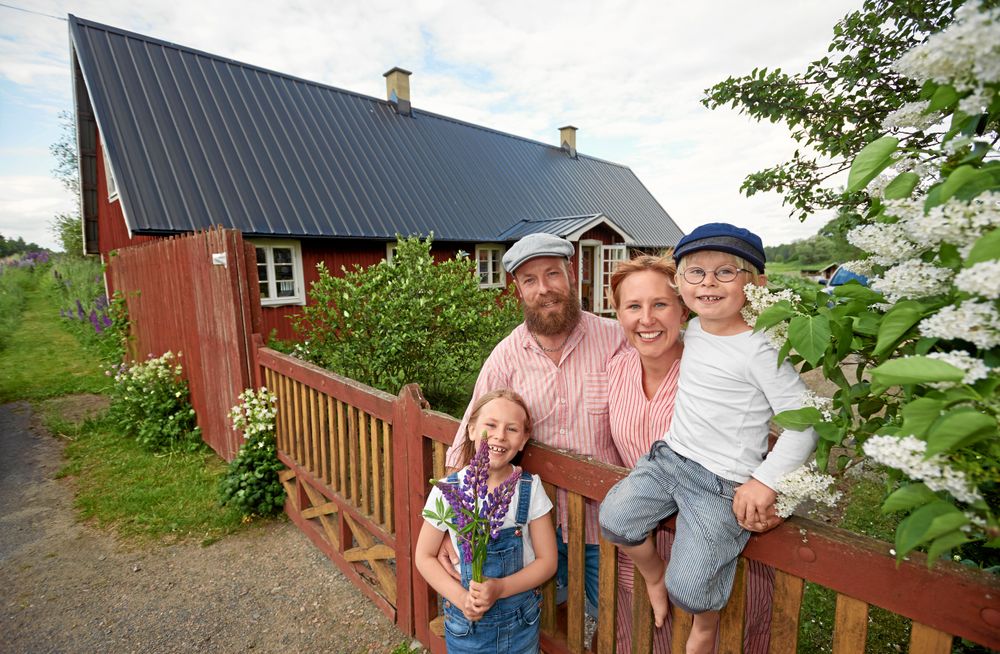David och Lella Ernstedt och deras två barn Vendeli och Atle framför sitt ovanliga boende – i en backstuga.