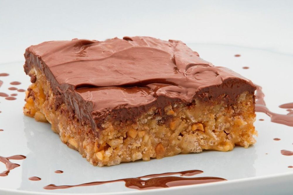 En chokladtoppad nötbar på en vit tallrik.
