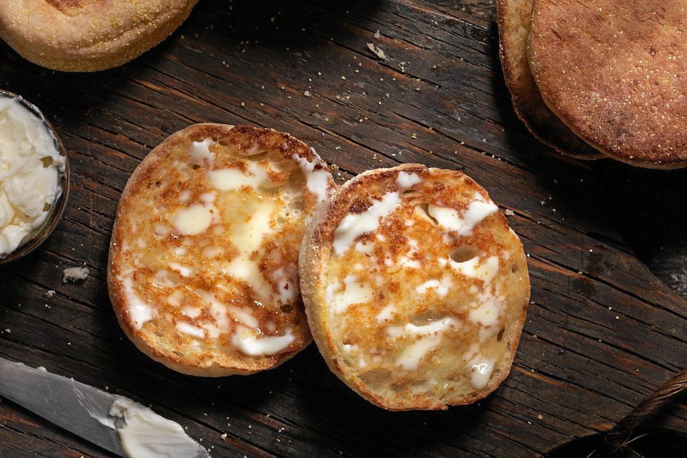 Bred rikligt med smör på ännu varma nyrostade engelska muffins.