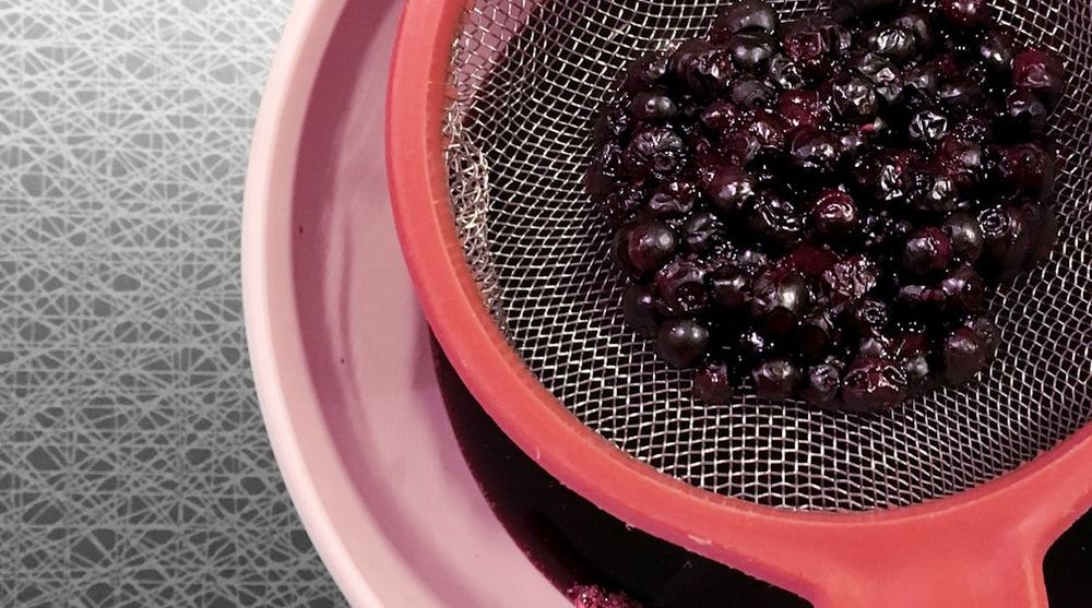 Röd sil med mörka bär över en rosa skål