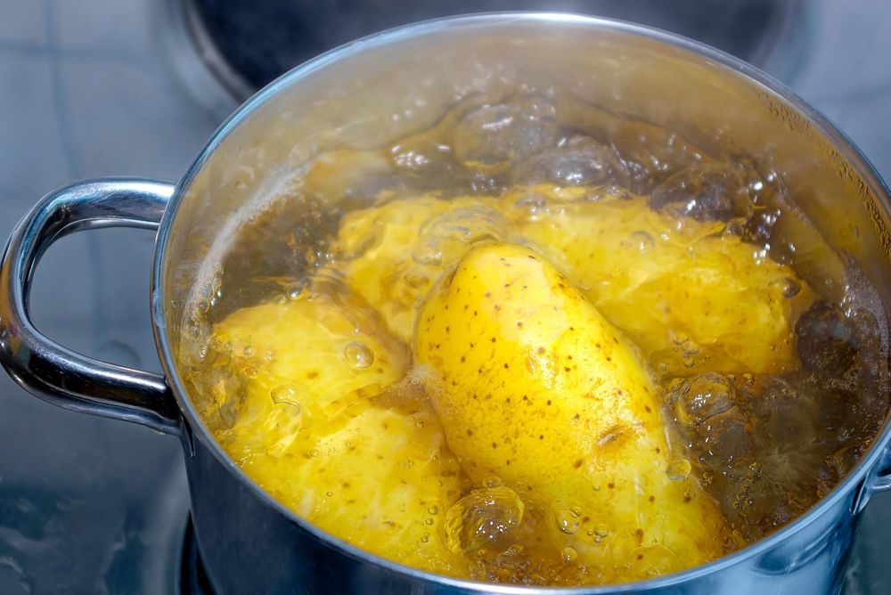 Potatis kokar i kastrull.