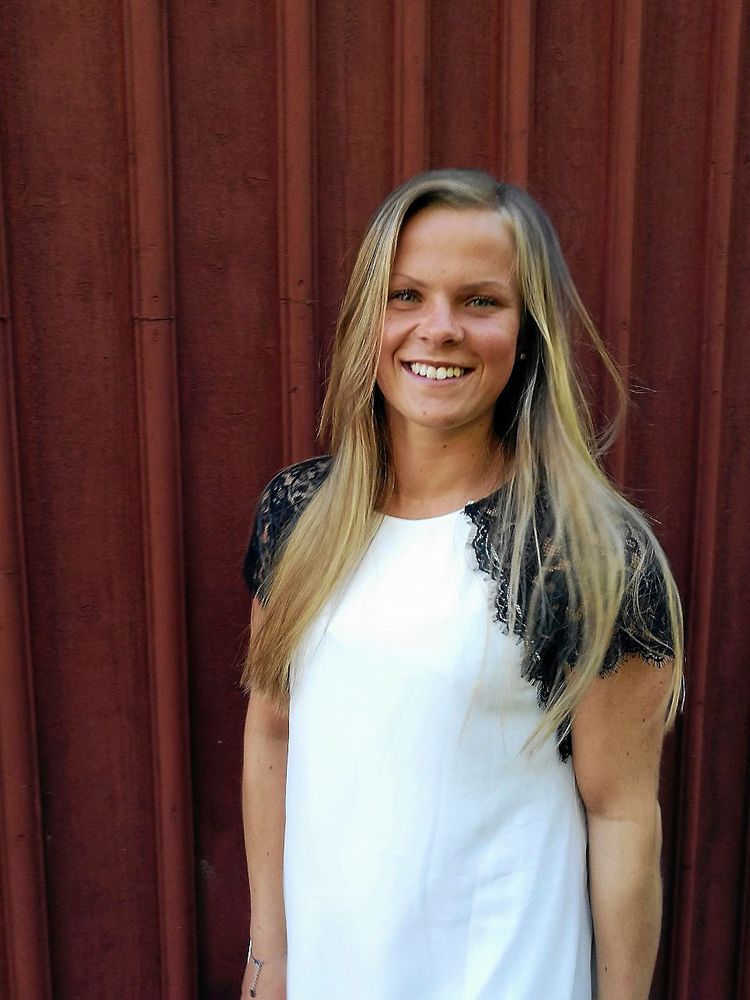 Nellie Hultman framför husfasad.