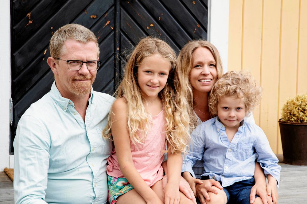 Lena Barkman, Magnus Lorentzon och barnen Ellen och Emrik sitter på trappan framför huset.