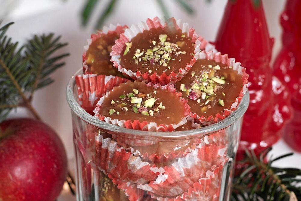 Julgodis med nötter i röda formar på ett fat.