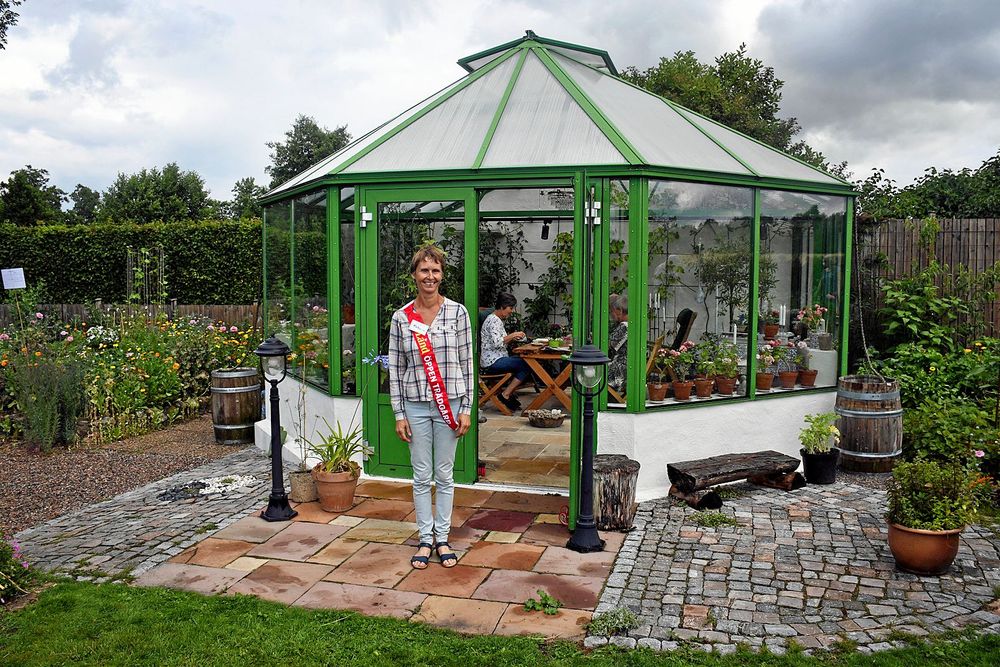 Katarina Olsson hade gott om gäster hela eftermiddagen i sin trädgård utanför Sollebrunn. Här står hon framför orangeriet som har en central plats i hennes trädgård.