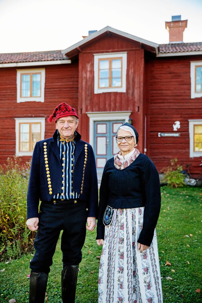 Lennart och Mona trivs i sina festfolkdräkter från Alfta. Monas förkläde är sytt i blommig kattun.