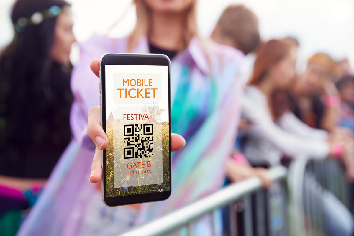 Person visar mobilbiljett med QR-kod vid entré till festival