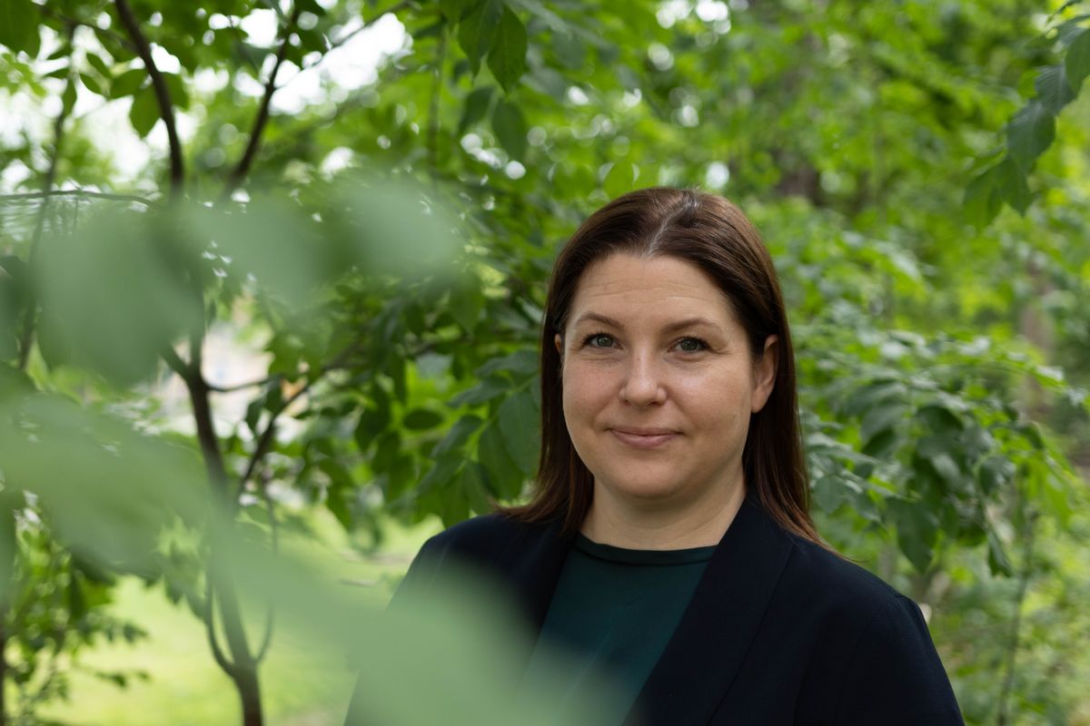 Porträtt av kvinna utomhus omgiven av grönska och träd