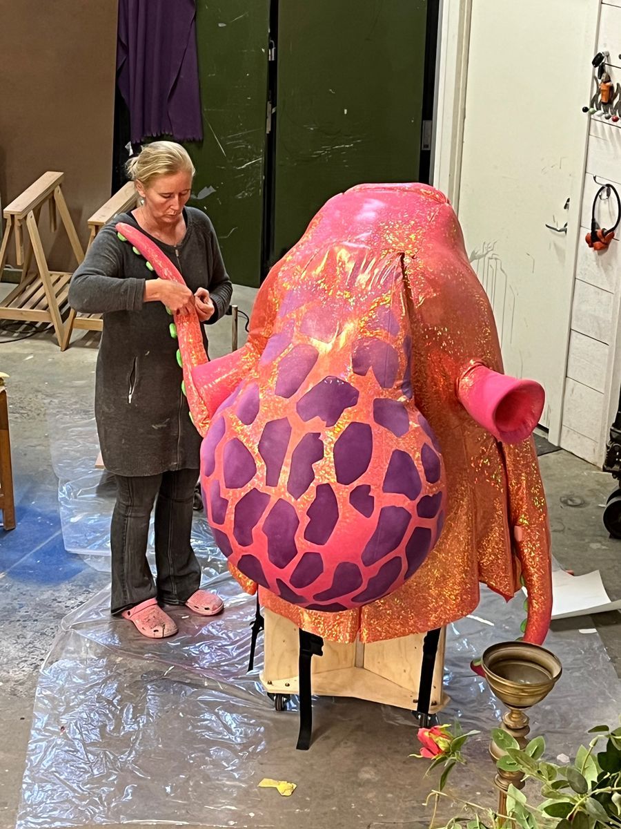 Eva-Karin målar en stor rosa och lila skulptur i en ateljé