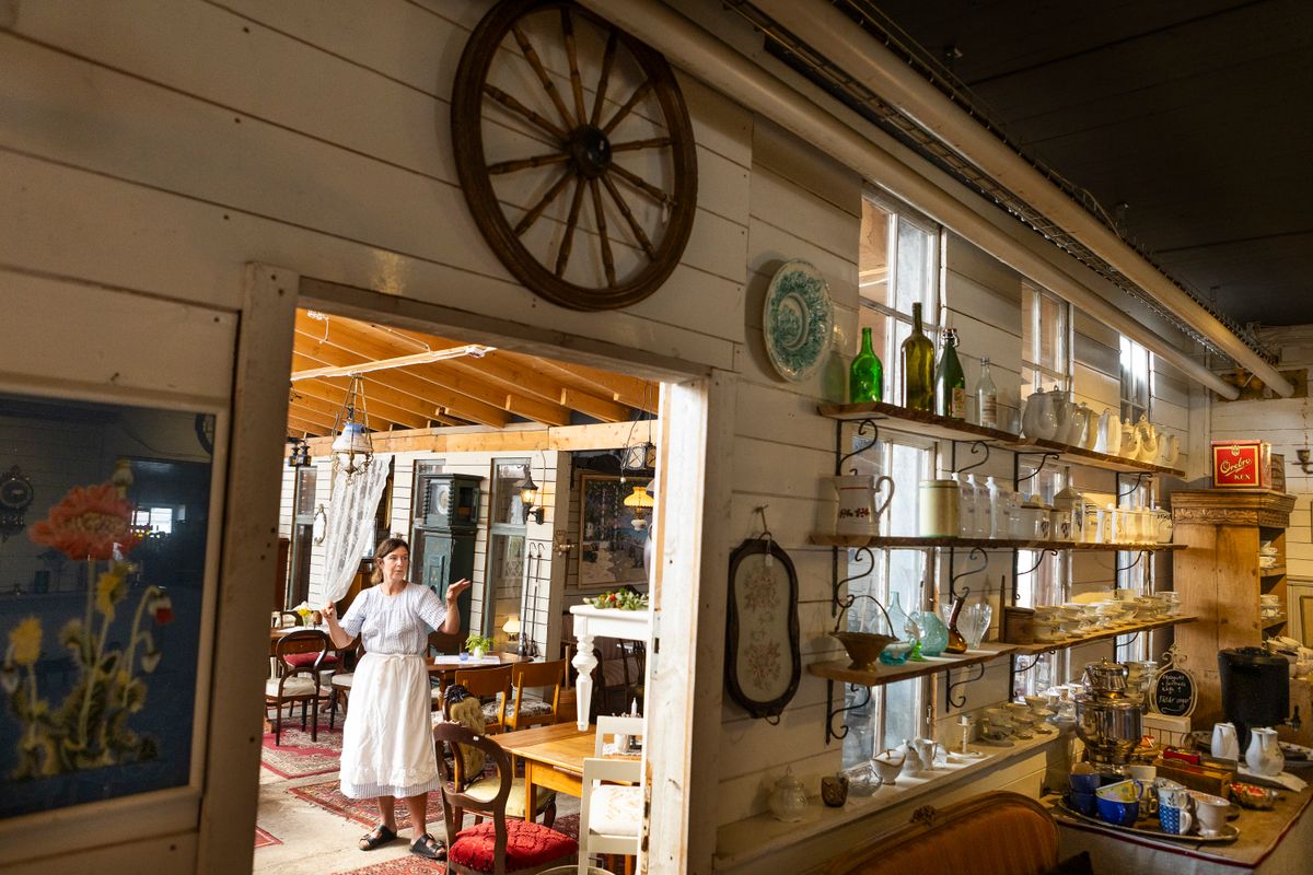 Ljust lantligt café med träväggar, gamla möbler och dekorerade hyllor
