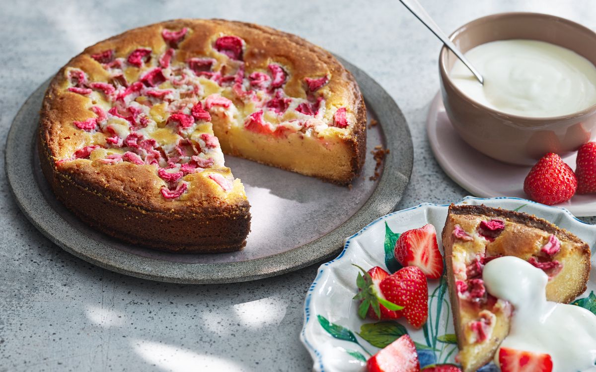 Rabarberkladdkaka på fat med en bit uppskuren och serverad med yoghurt