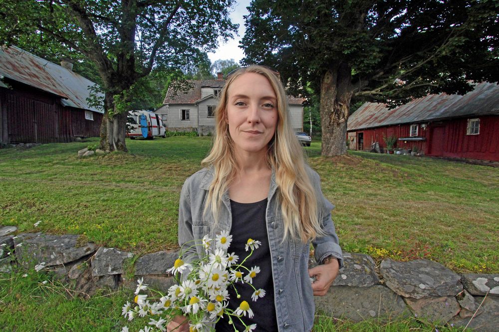 Emilia Lindholm framför sin ödegård med stort renoveringsbehov som hon köpte för 35 000 kronor.