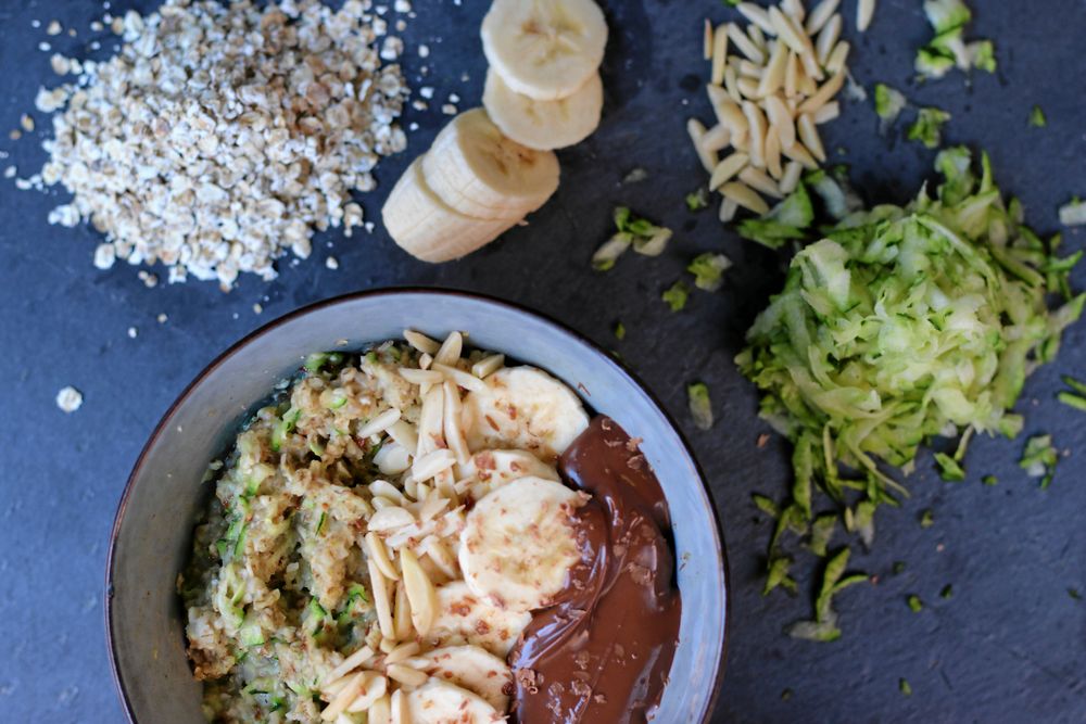Zoats är en gröt med riven zucchini i. Här är den toppad med skivad banan, hackade mandlar och hasselnötssmör.