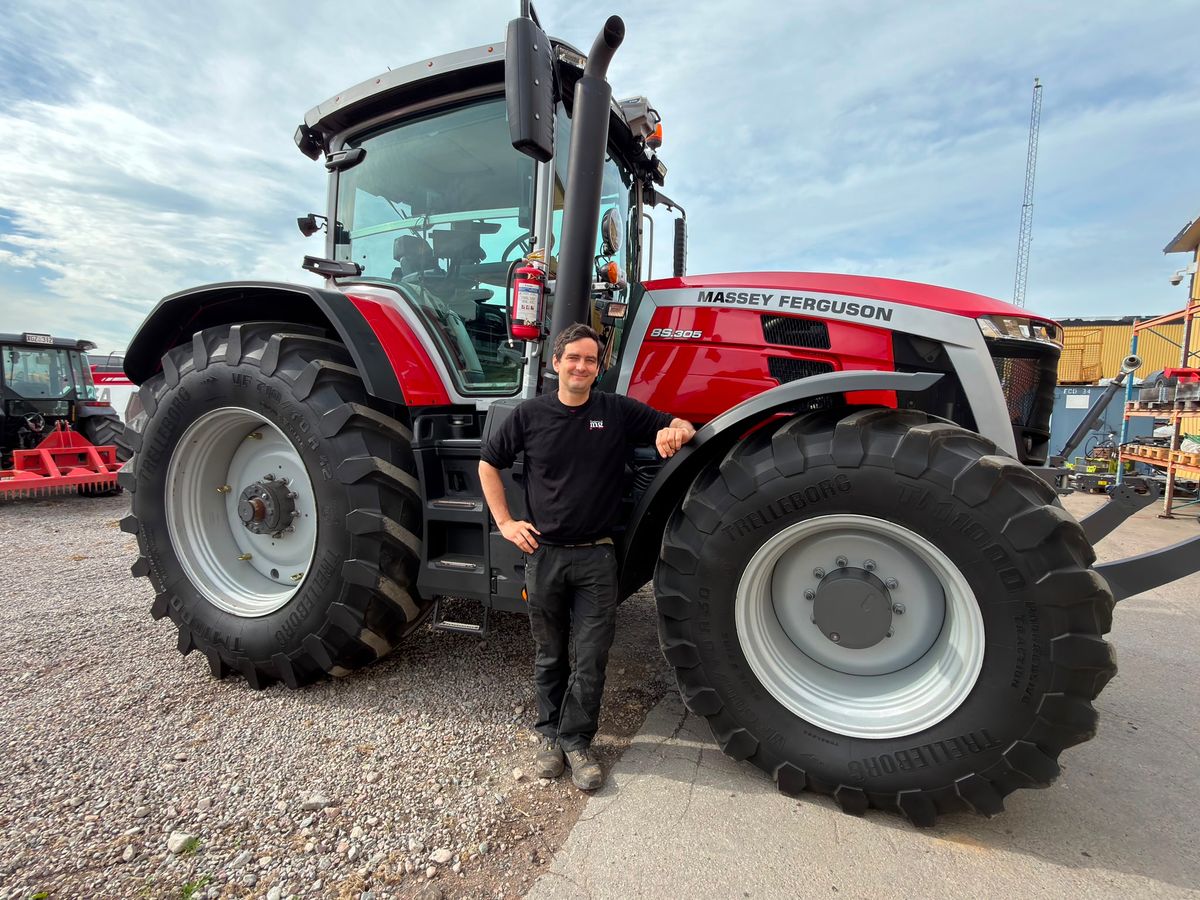 Man lutar sig mot röd traktor