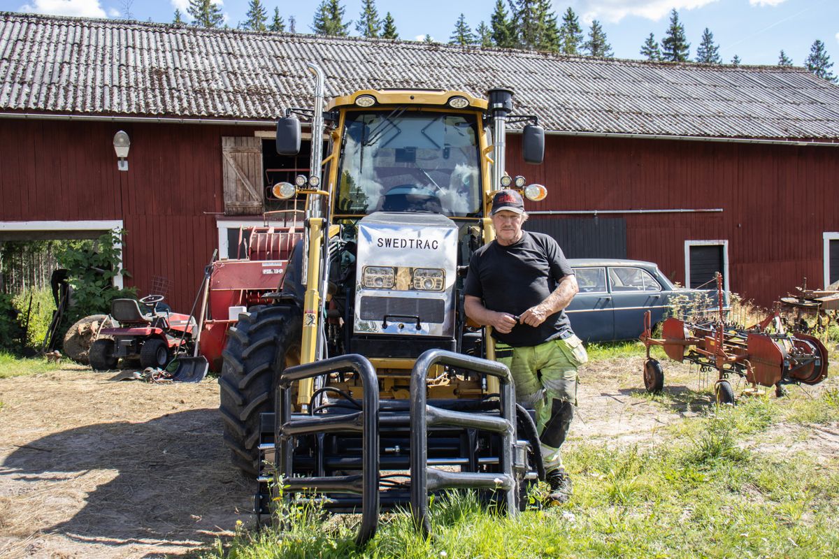 Man står vid traktor.