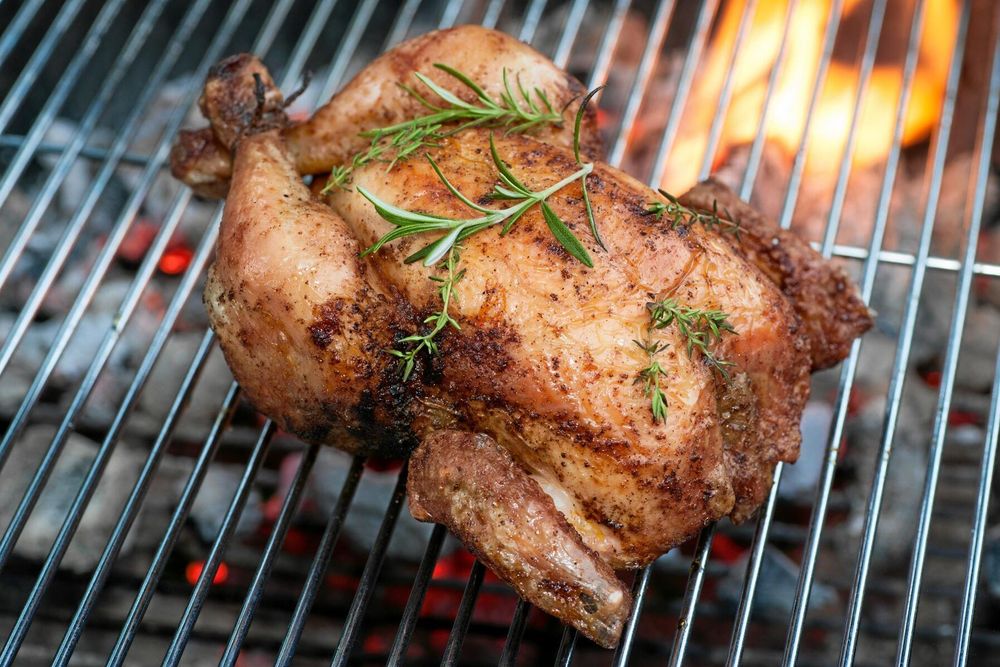 Grillad hel kyckling med rosmarin på utegrill.