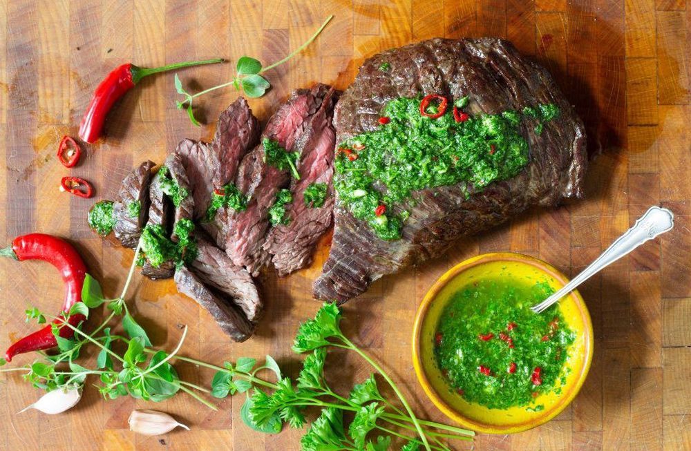 Chimichurri i skål bredvid grillad köttbit.