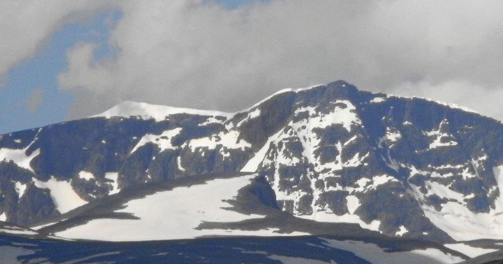 Den snöklädda toppen till väster är Kebnekaises sydtopp. Den mörka till höger är nordtoppen. Bilden är tagen i juli 2011 och då var sydtoppen något över 2 100 meter över havet.