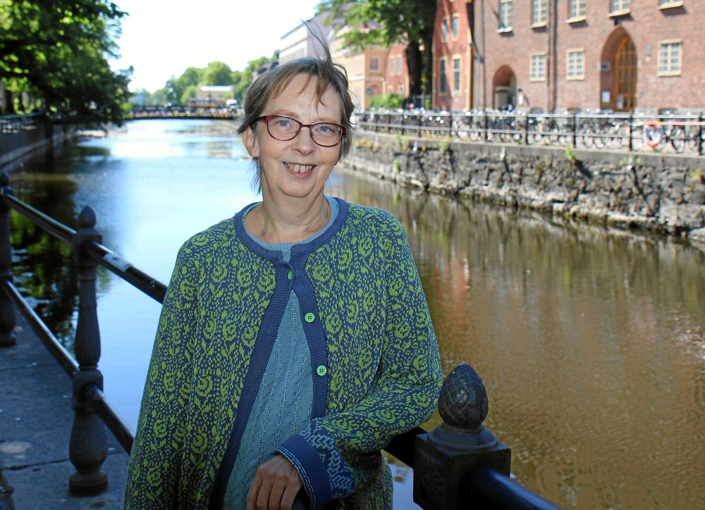 Nina Mohss i spräcklig kofta står vid kanal.