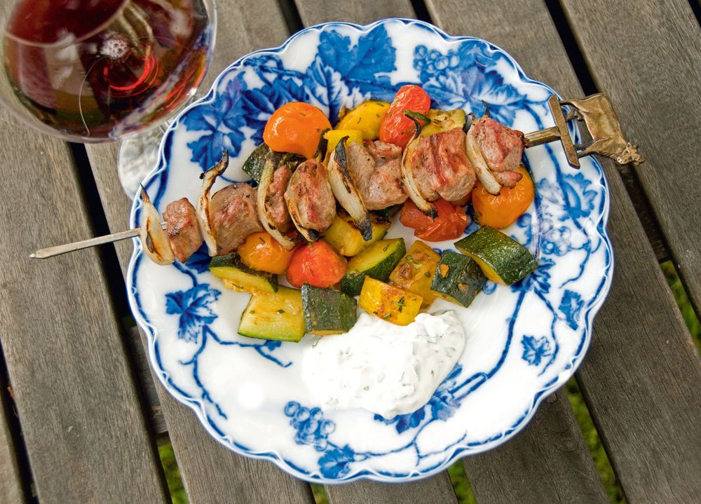 Servera lammspetten med wokad squash, tomat och vitlök.