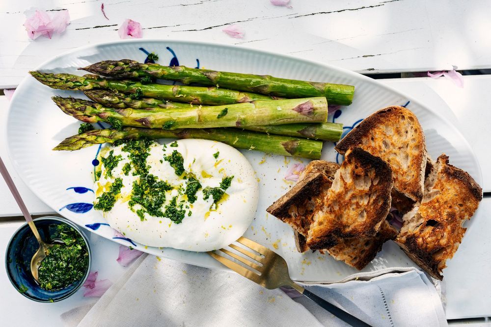 Gremolata på pocherat ägg på tallrik med sparris.