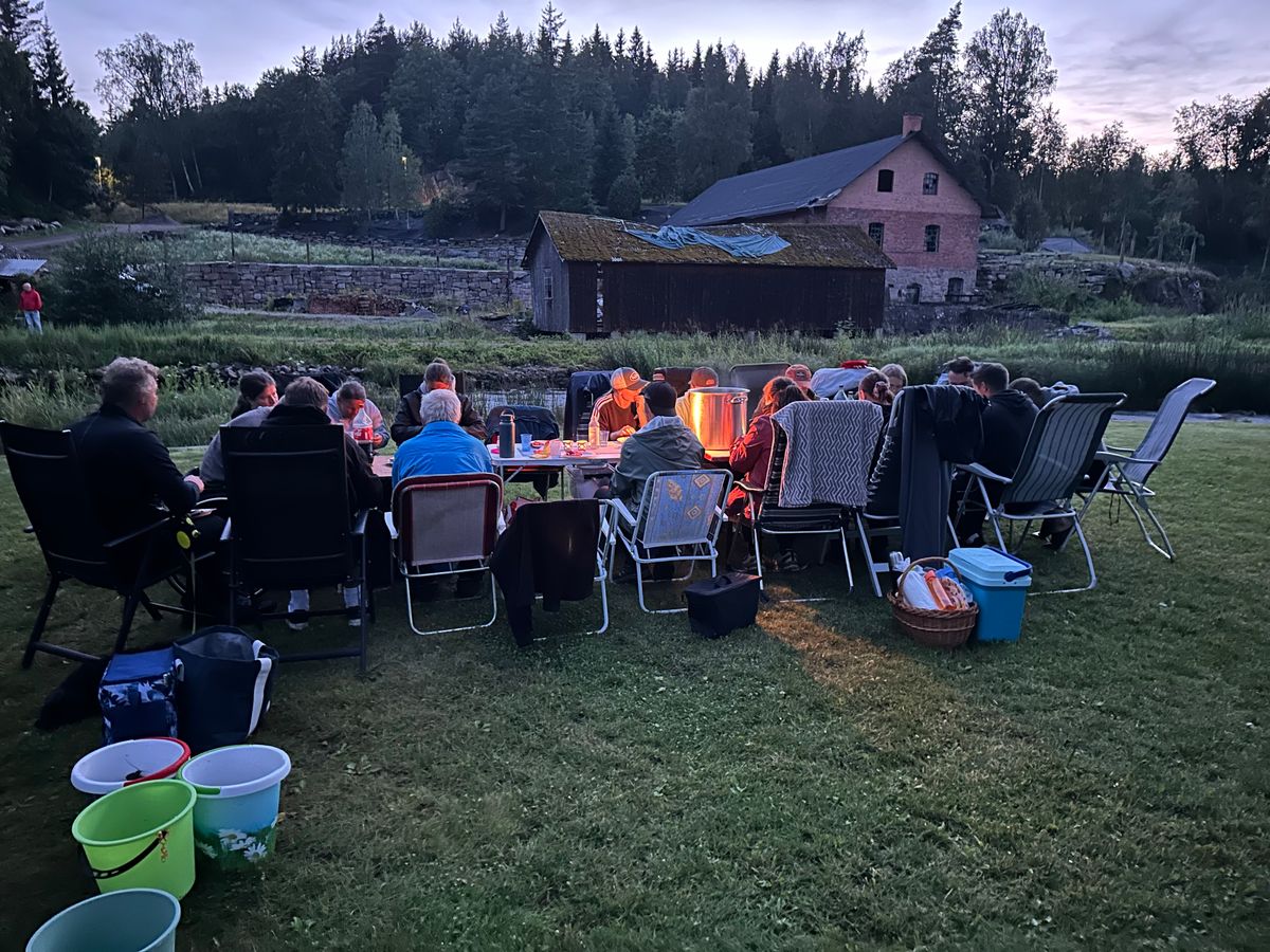 Kräftskiva. Familjen Andersson samlade runt ett upplyst bord utomhus en sommarkväll på landet