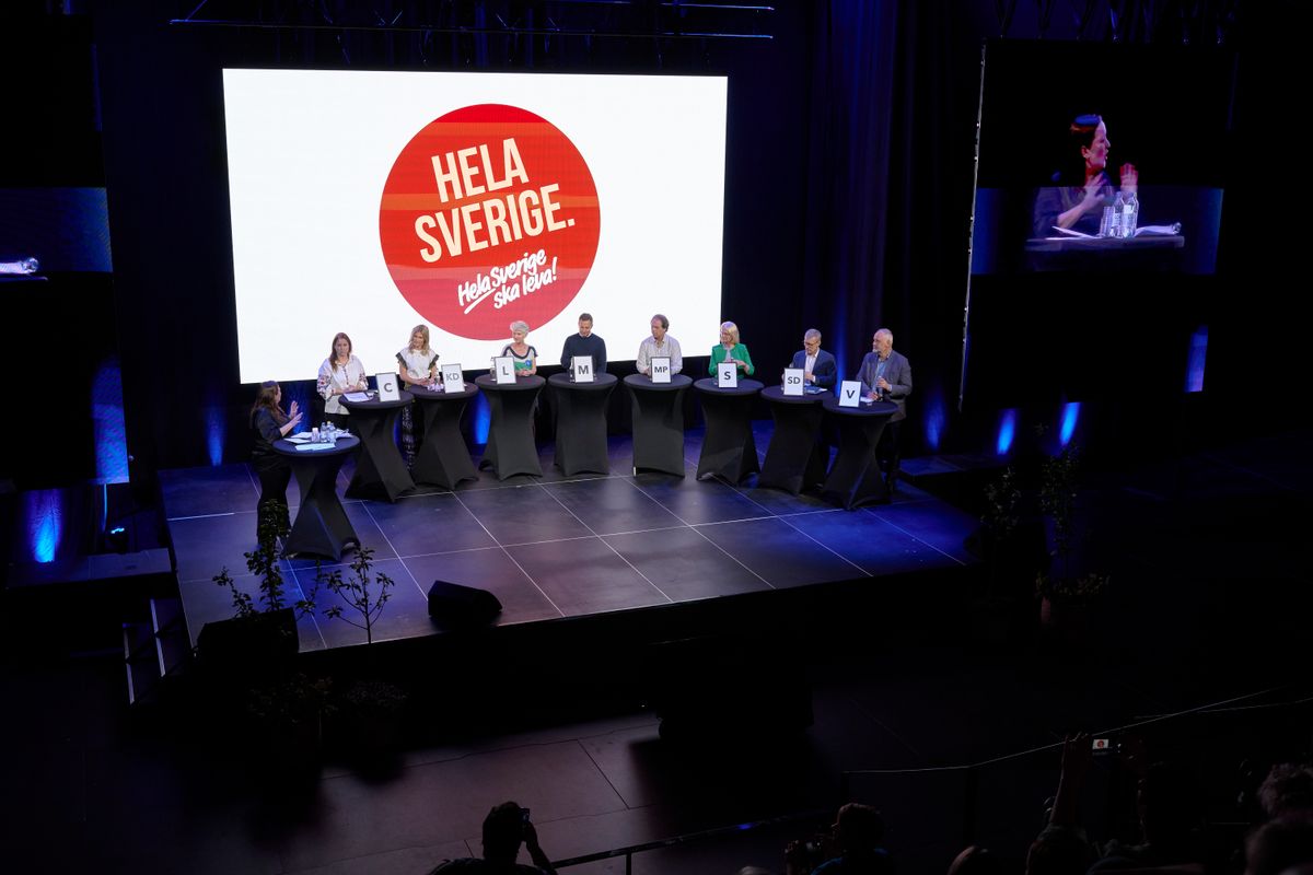 Paneldebatt på scen framför stor skärm med texten ”Hela Sverige”.