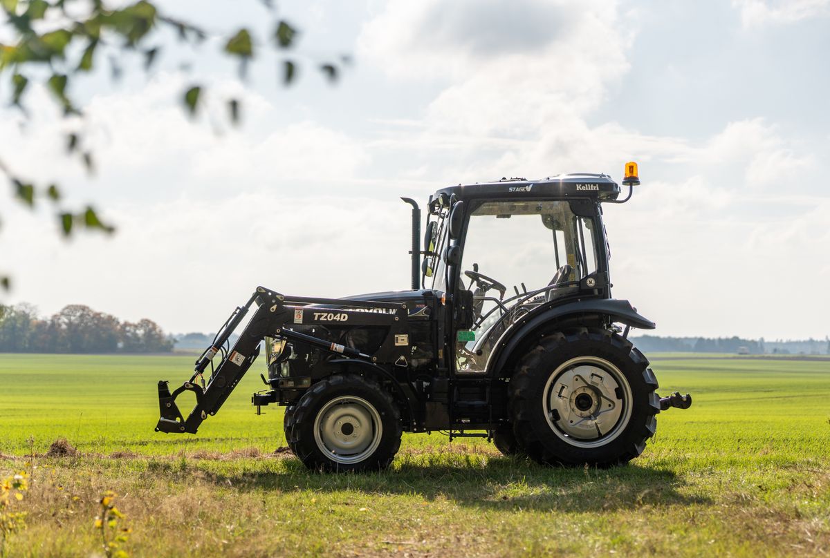 Svart traktor med frontlastare.