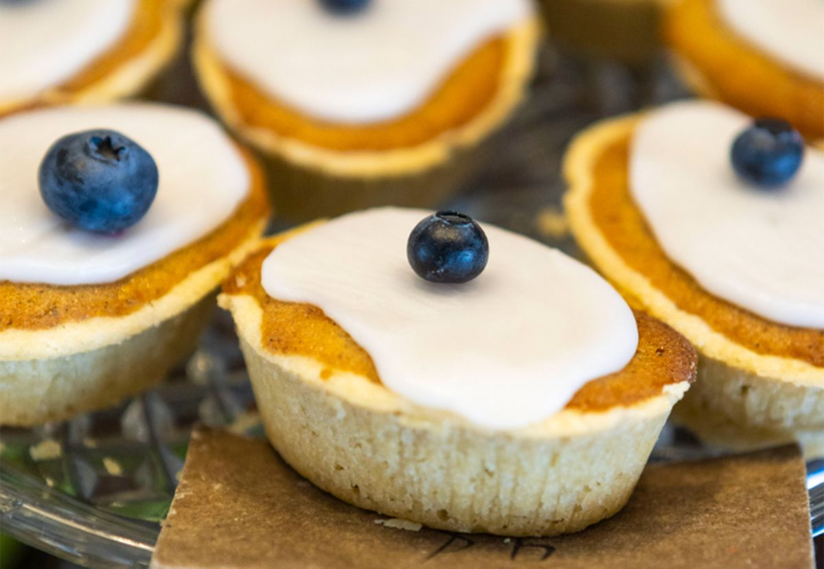 Små kardemummamuffins med vit glasyr och blåbär på ett serveringsfat