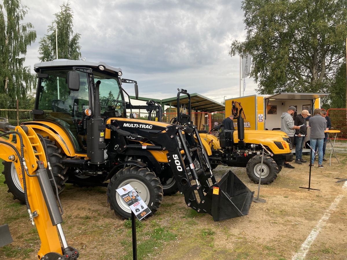 Gul traktor står i mässmonter.