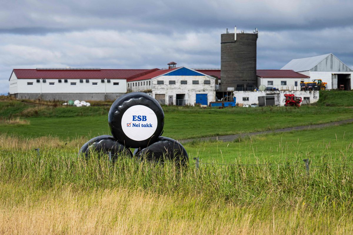 Lantgård med rundbalar, en med texten ”ESB Nei takk” i förgrunden.