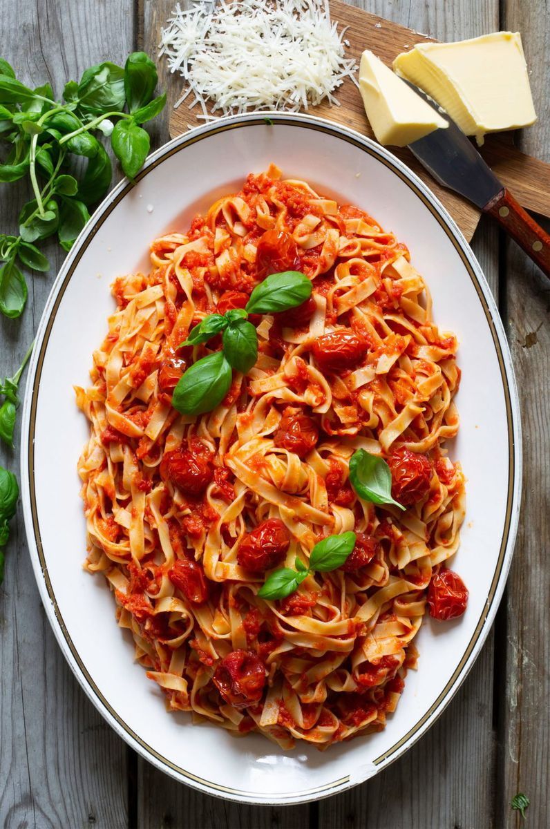 Ovalt serveringsfat med kokt tagliatelle i tomatsås.