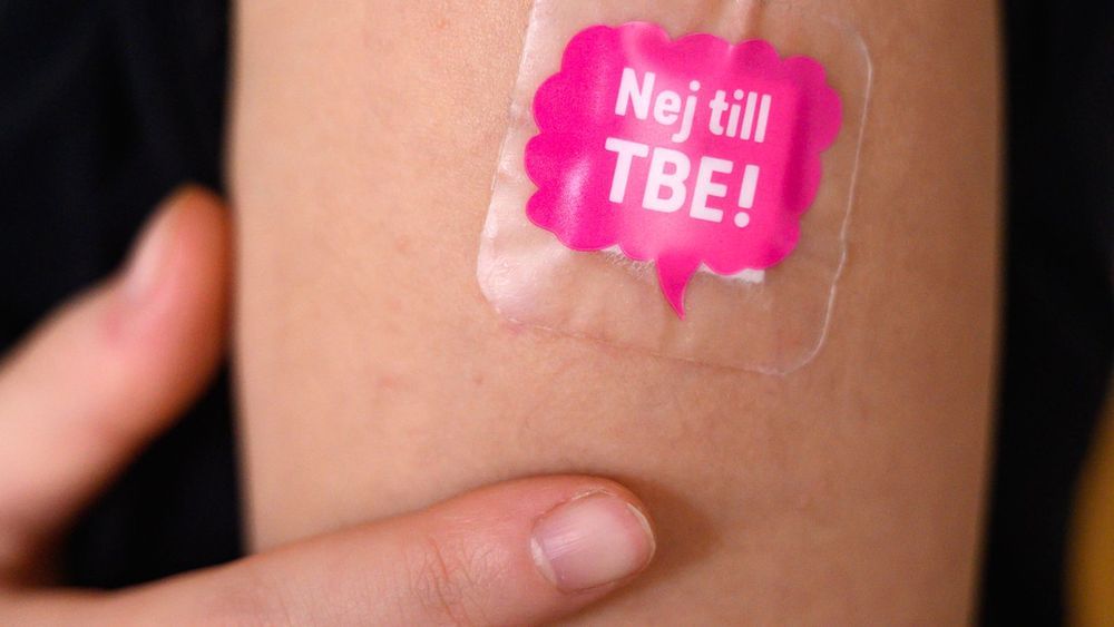 Kvinnoarm med plåster där det står ”Nej till TBE!”.