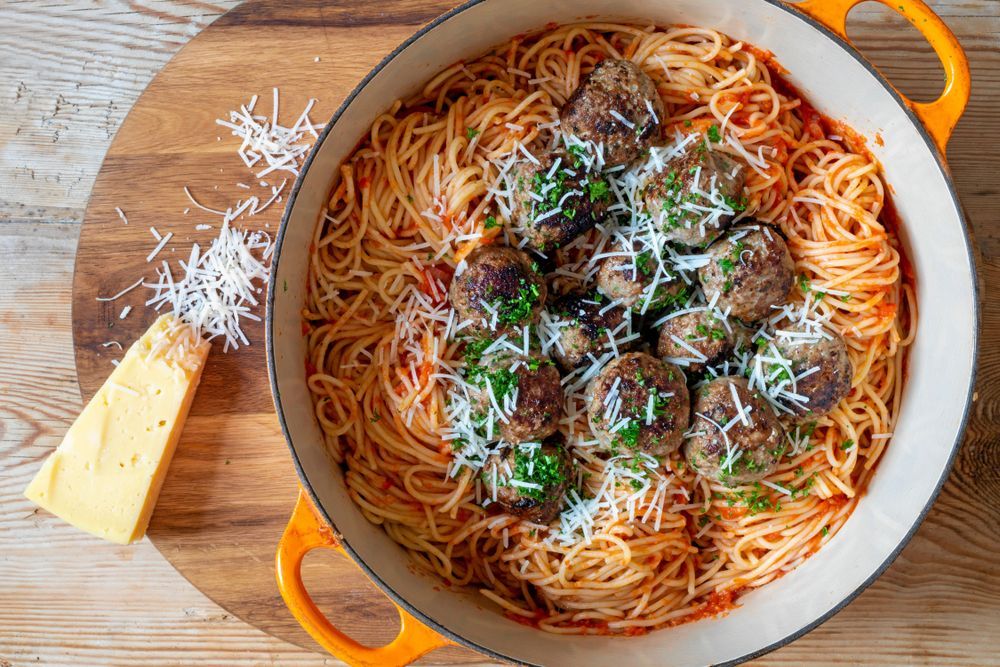 Köttbullar och spagetti i kastrull.